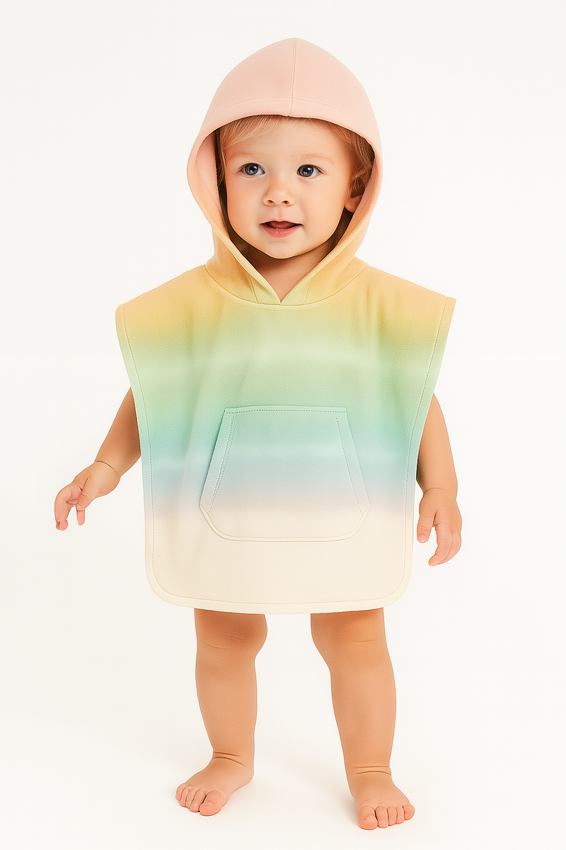 Baby wearing a colorful hooded towel with a gradient design on a white background