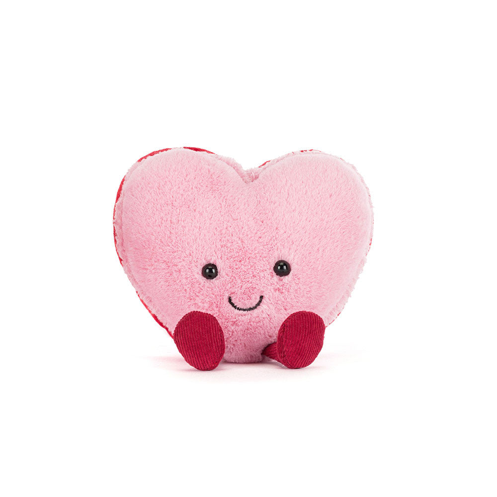 Heart-shaped plush toy with a smiley face on a white background
