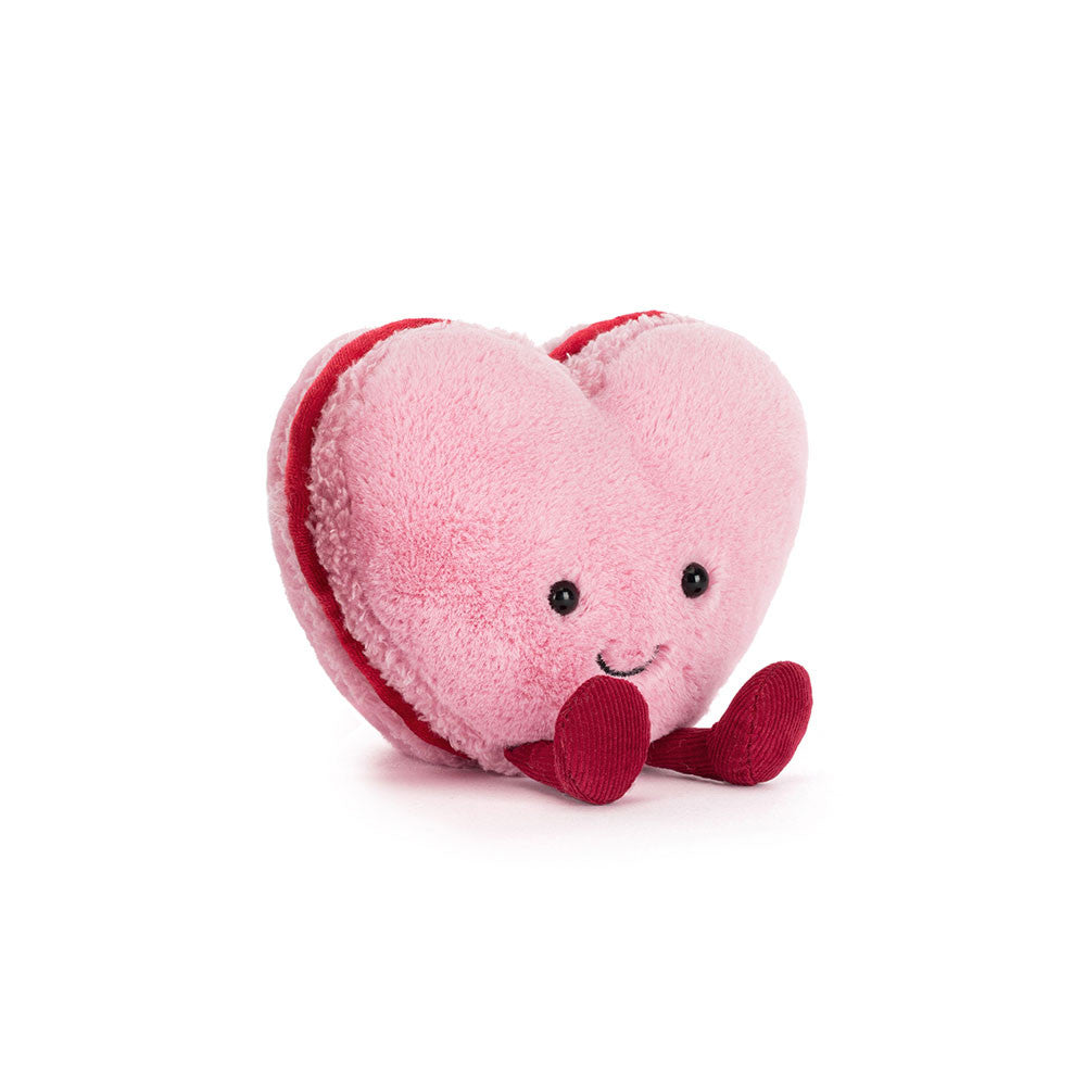 Heart-shaped plush toy with a smiling face on a white background