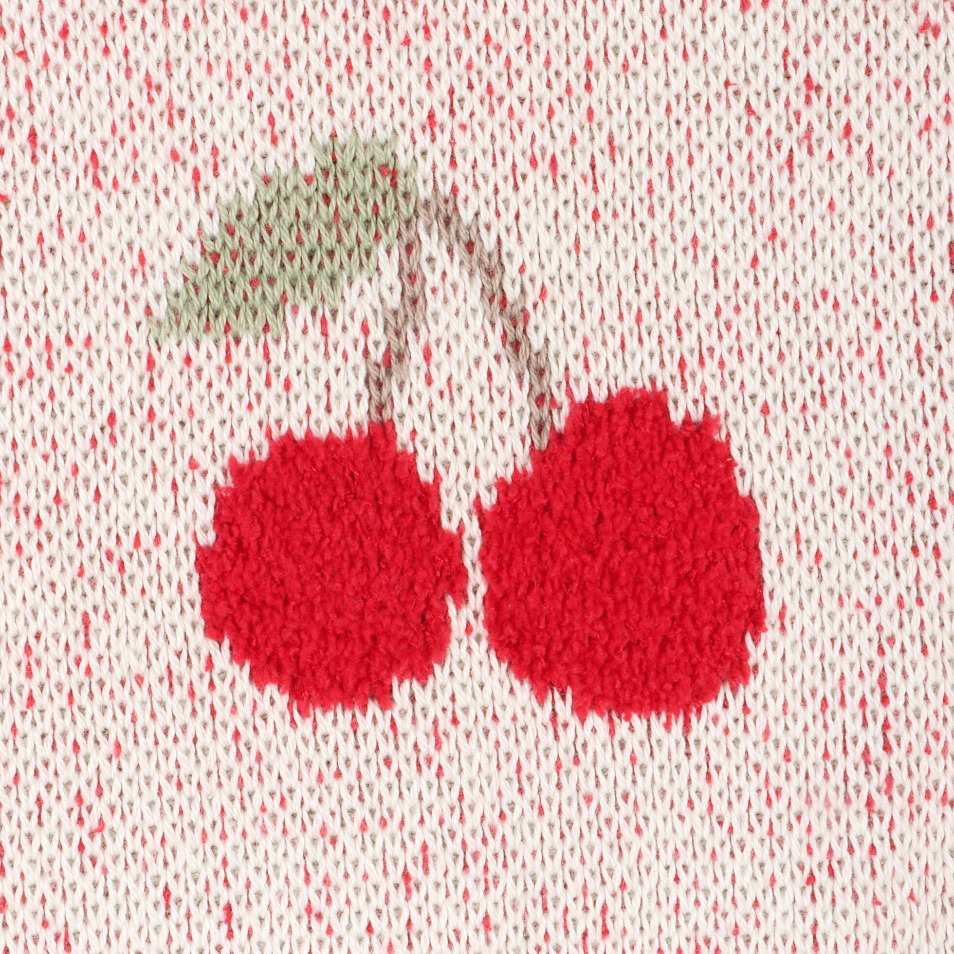 Close-up of cherry design blanket on a textured fabric background