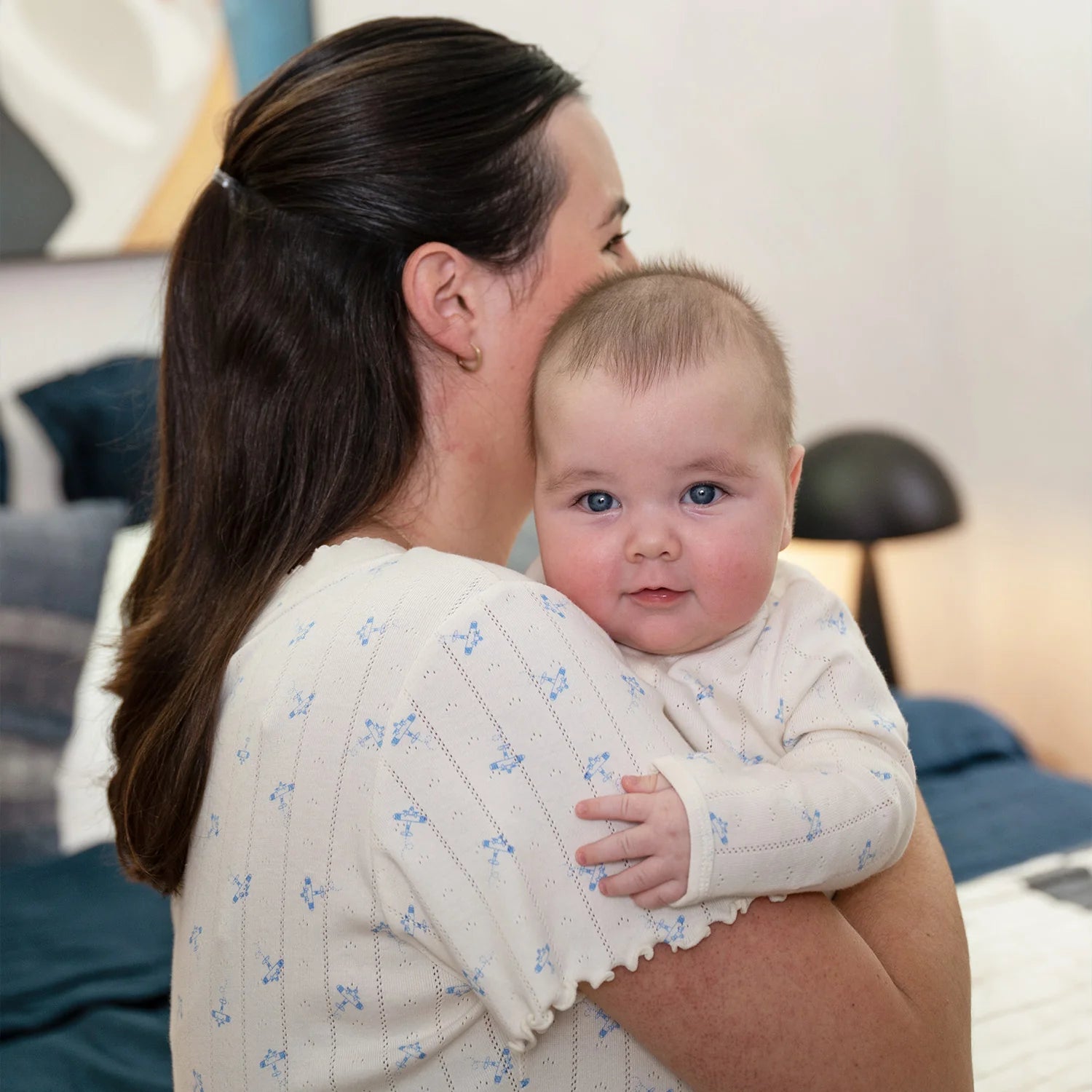 Woman holding a baby in a home setting