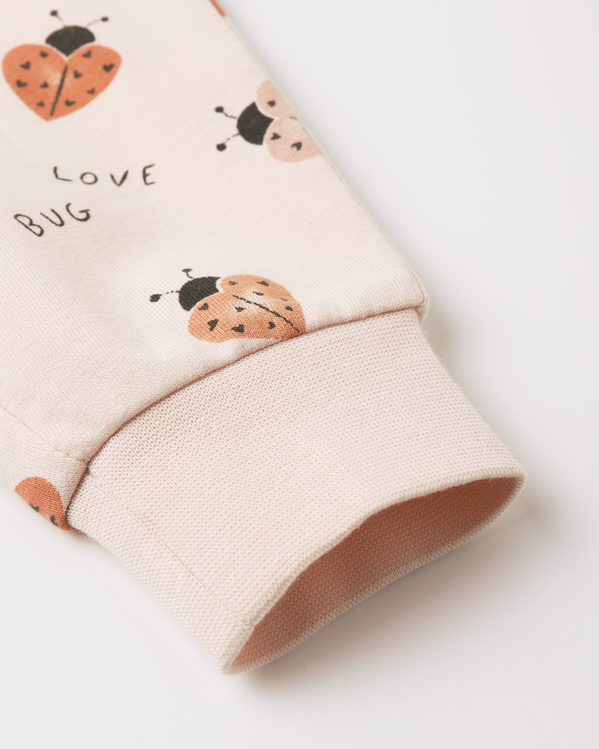 Children's sleeve with ladybug design and 'Love Bug' text on a light background