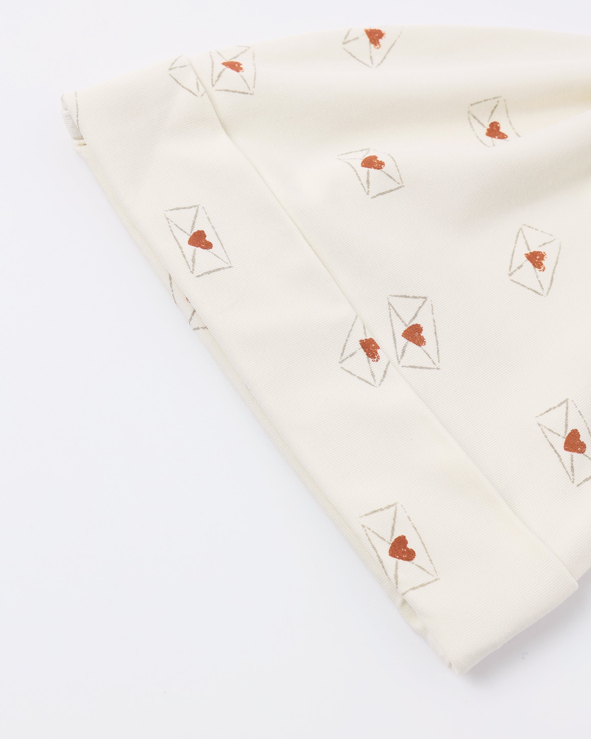 Folded fabric with heart and envelope patterns on a white background