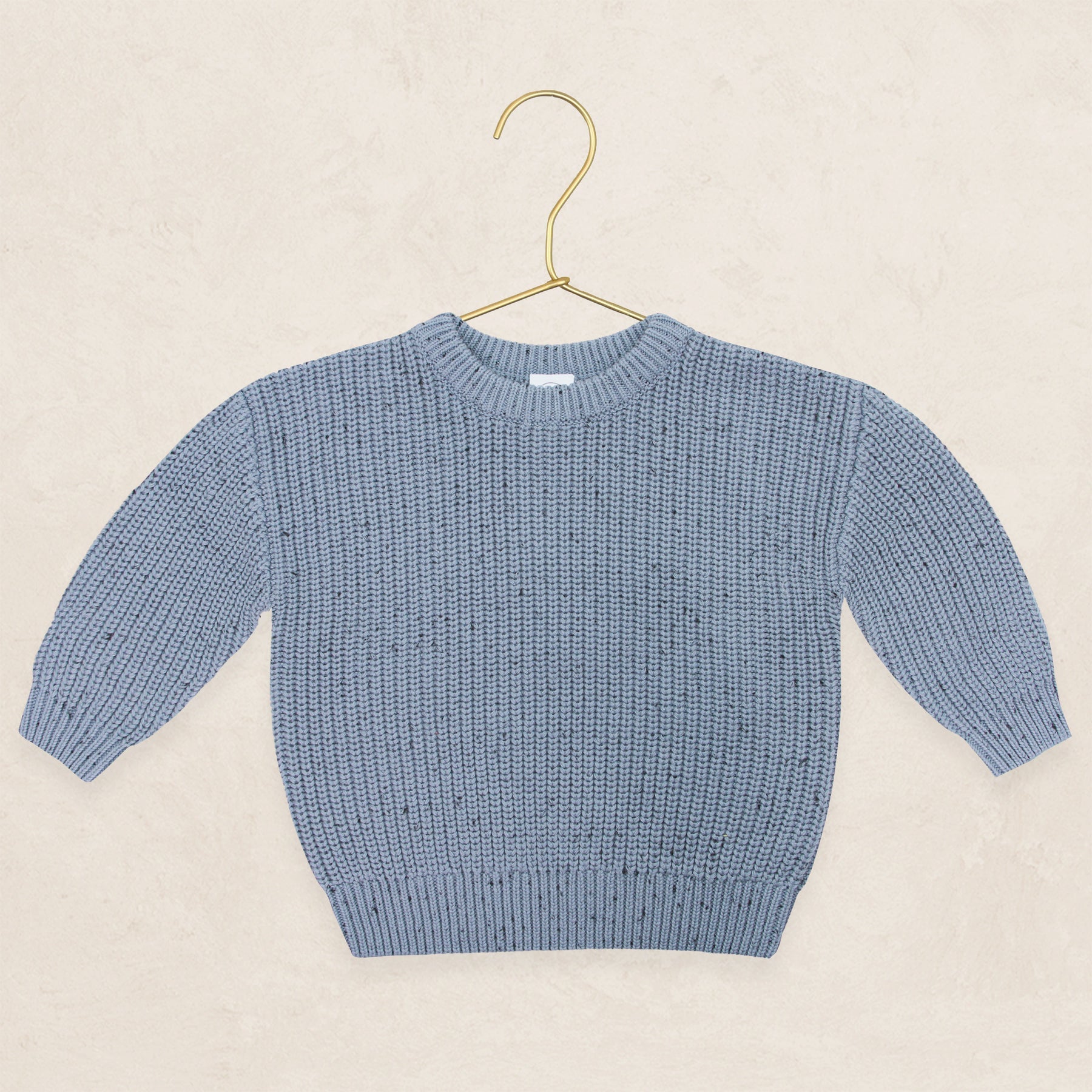 Cadet Sparkle chunky knit sweater on a gold hanger, cozy and warm.