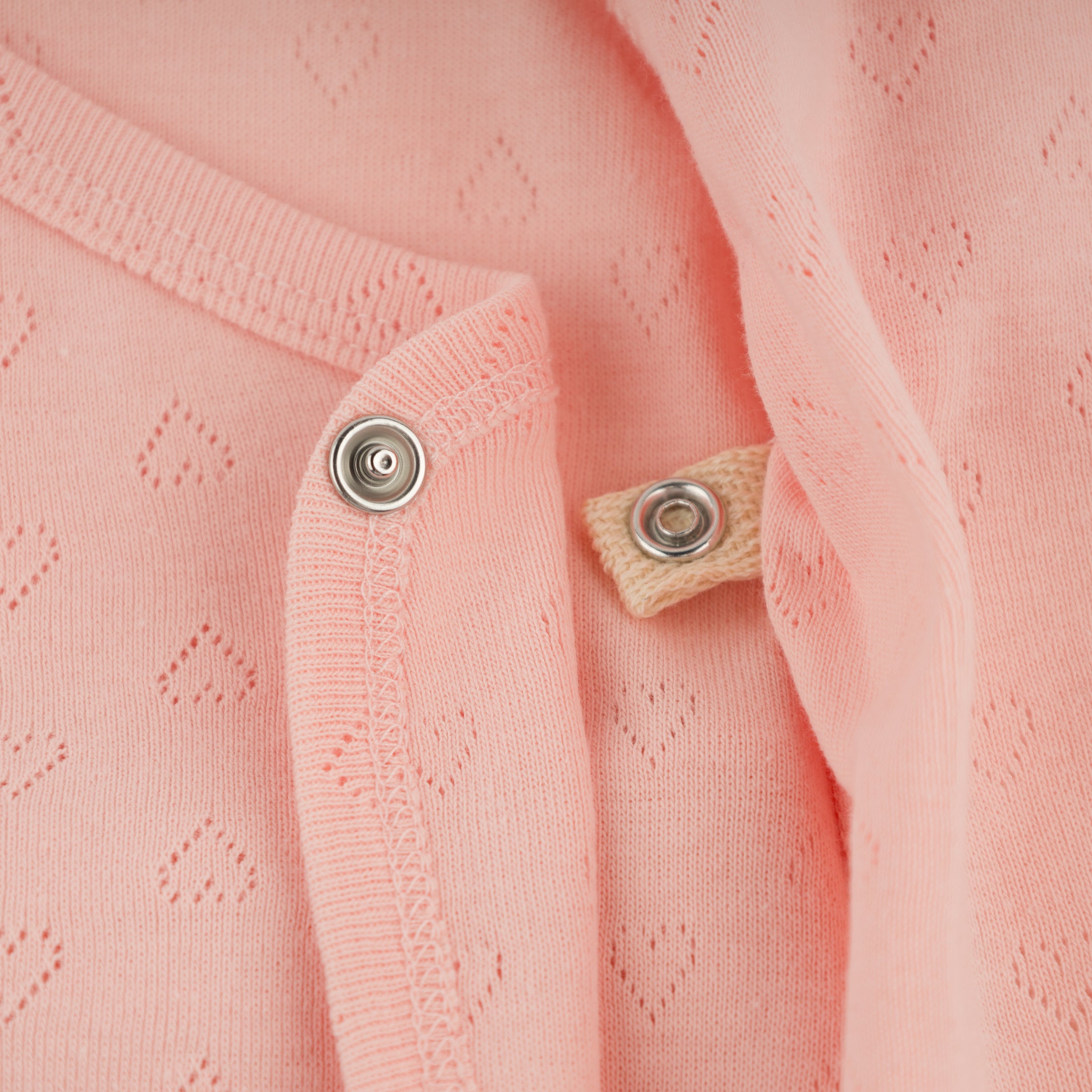 Close-up of a pink textured fabric with buttons