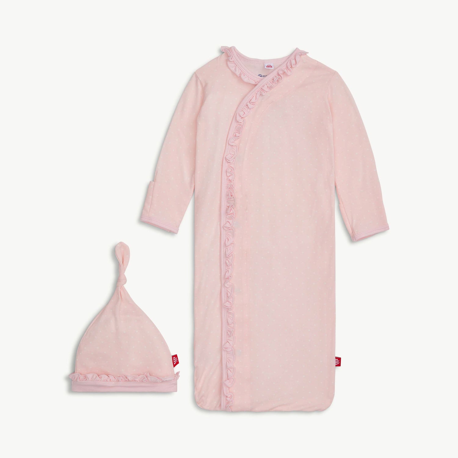 Pink baby gown with ruffled details and matching hat on a light gray background