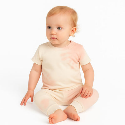 Baby wearing a light pink outfit on a white background