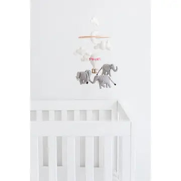 White crib with a baby mobile featuring elephants on a white background