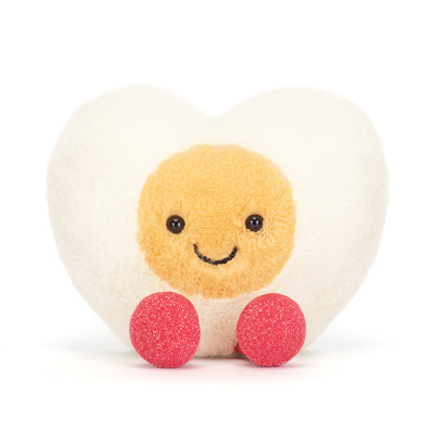 Round plush toy with a smiling face, beige body, and pink legs on a white background
