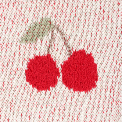 Close-up of cherry design blanket on a textured fabric background