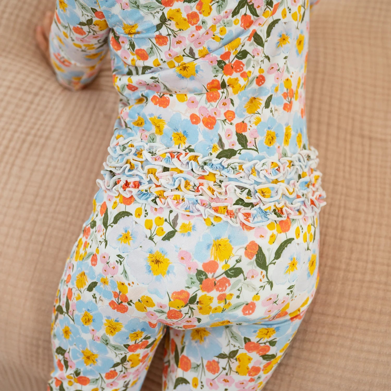 Floral patterned outfit on a child against a beige background