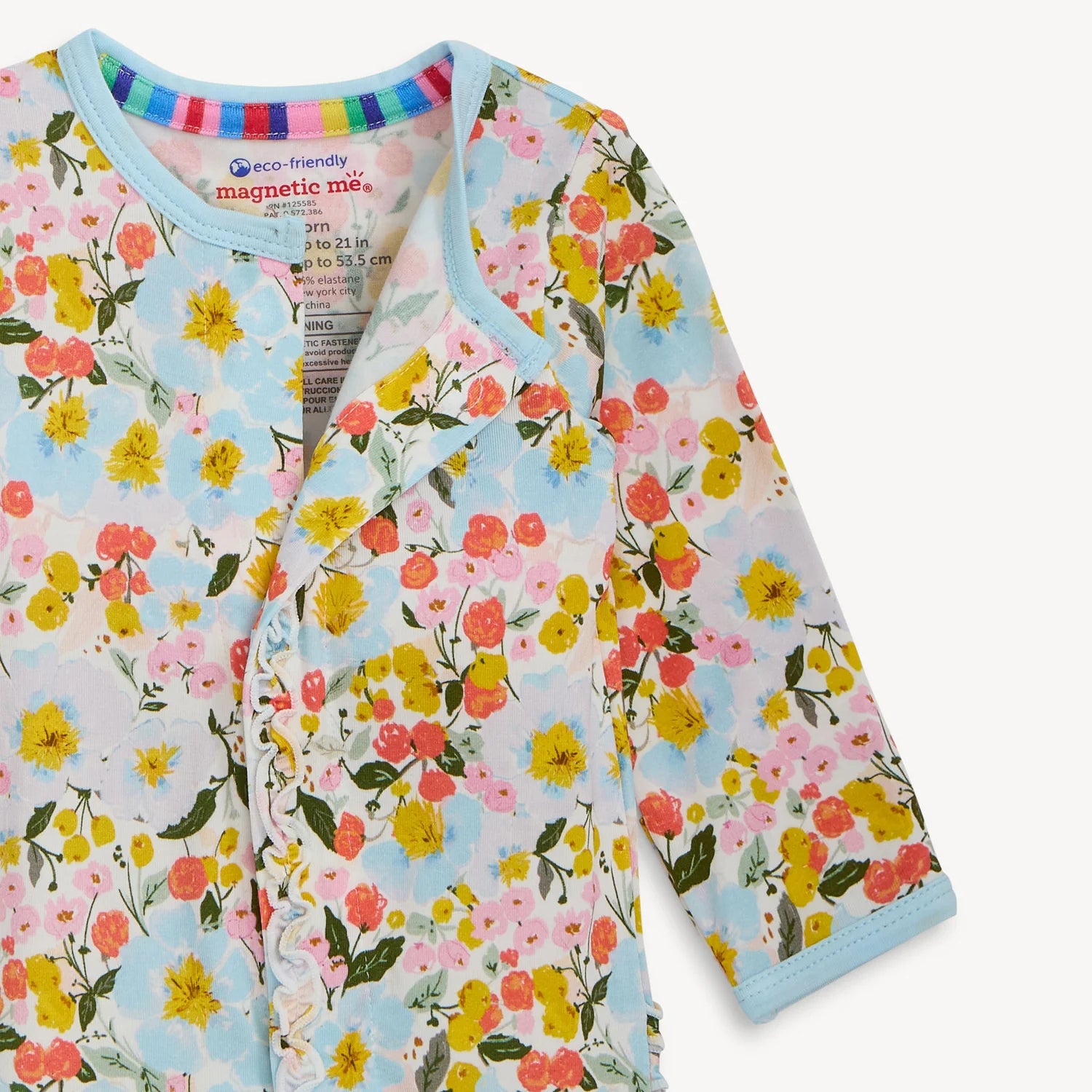 Floral-patterned baby outfit with 'magnetic me' label on a light background