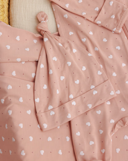 Pink polka dot dress with a knot detail on a beige background