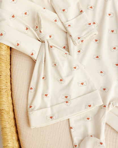 White fabric with red heart patterns draped over a wicker chair.