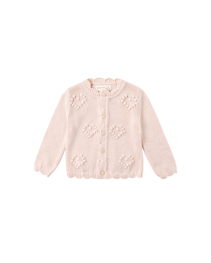 Pink knitted cardigan with floral patterns on a white background