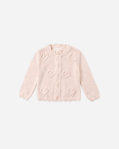 Pink knitted cardigan with floral patterns on a white background
