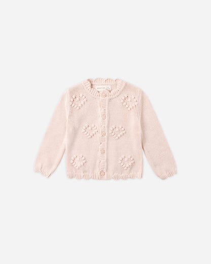Pink knitted cardigan with floral patterns on a white background