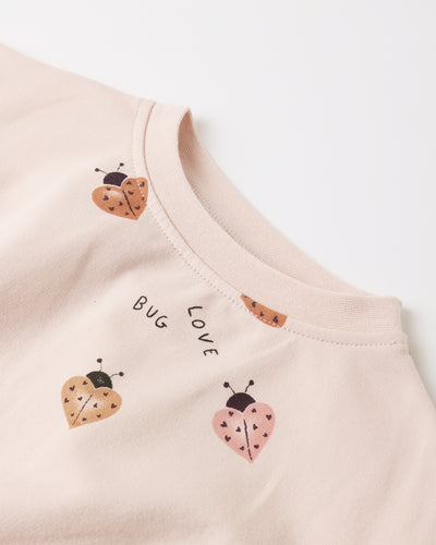Pink baby outfit with ladybug designs and text on a white background