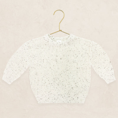 Cream speckle knit chunky sweater hanging on a gold metal hanger.