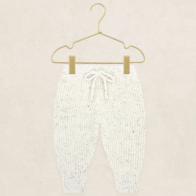 Cream speckle knit chunky jogger pants with drawstring, hung on a gold hanger.