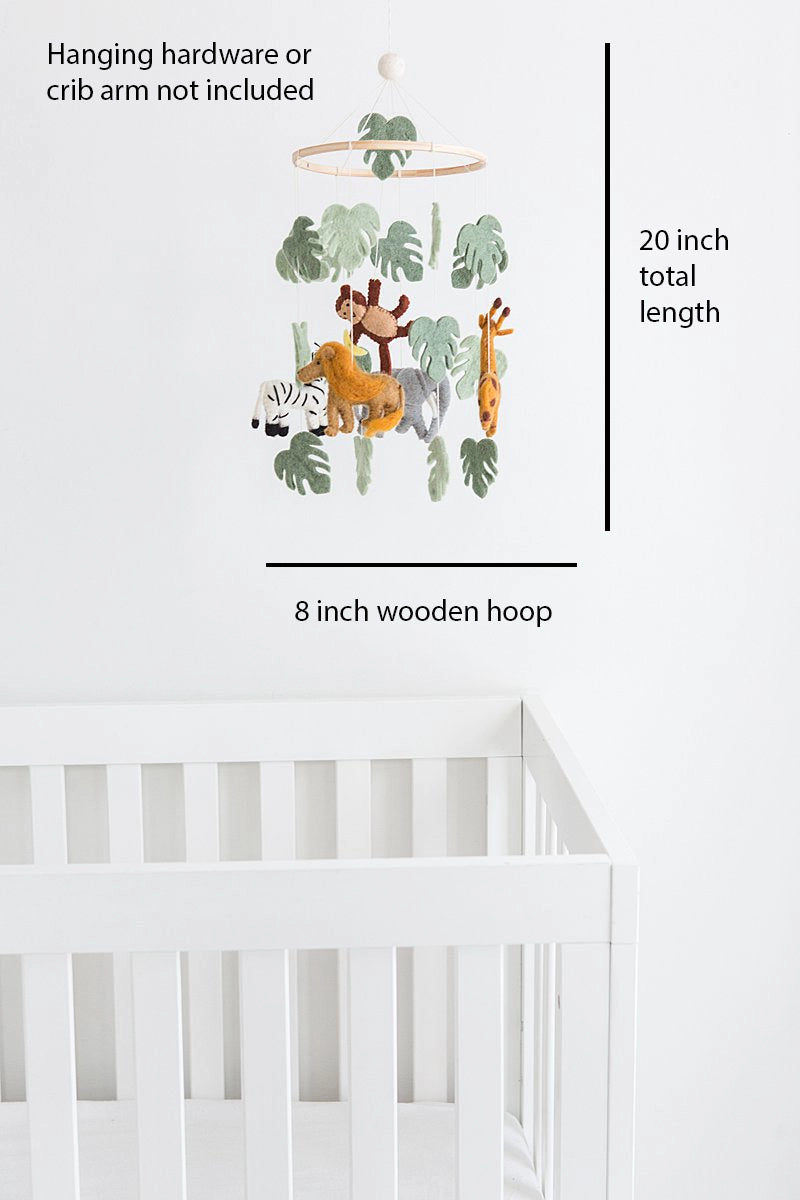 Baby crib mobile with animals and leaves on a white crib