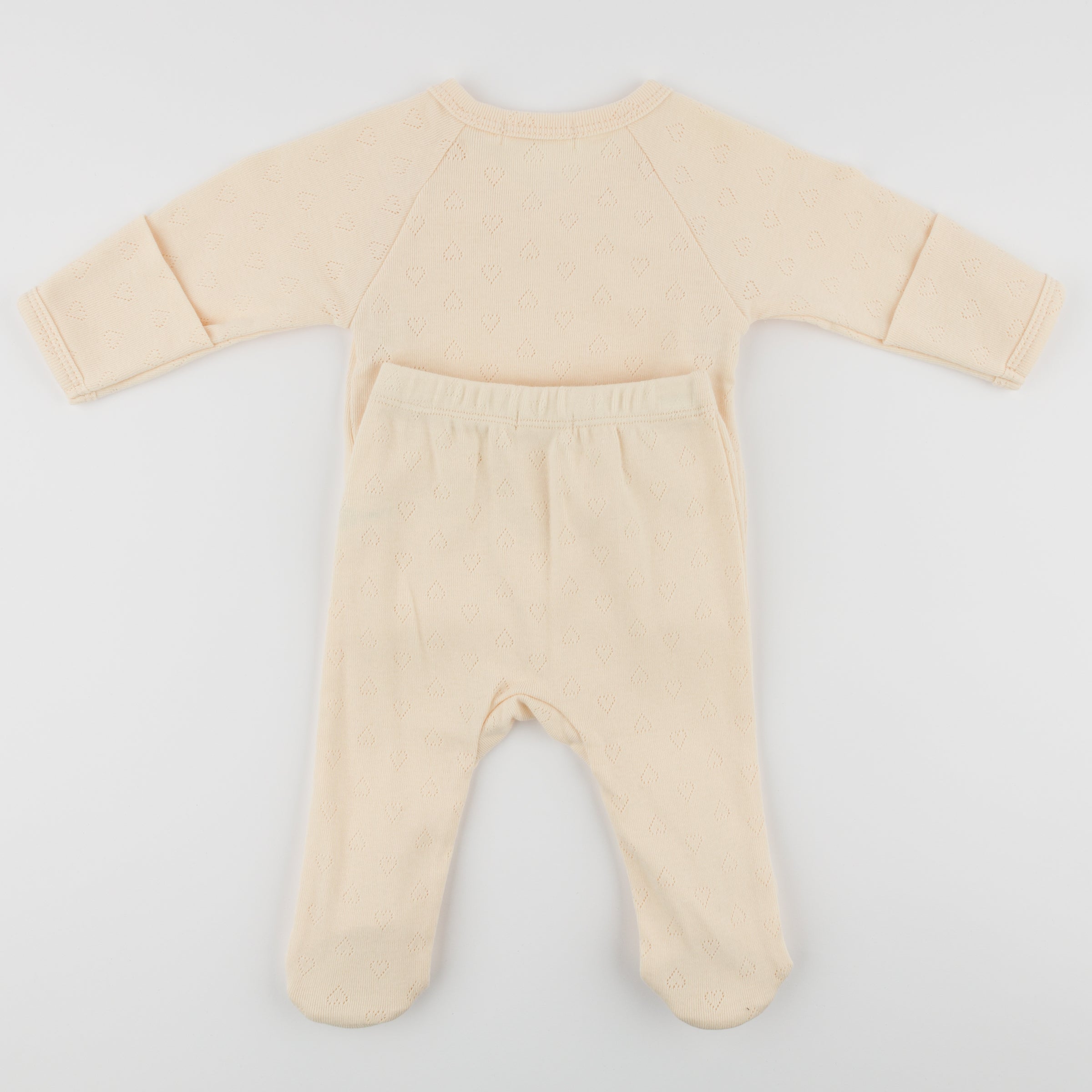 Beige baby onesie with long sleeves and legs on a light gray background