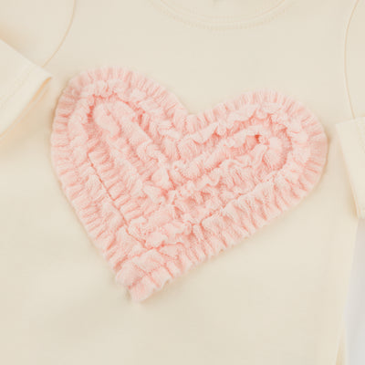 Pink heart-shaped bath mat on a beige surface